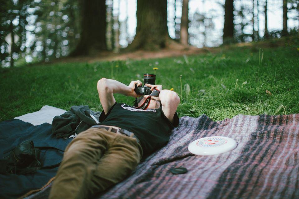 Mn lying on blanket taking a picture