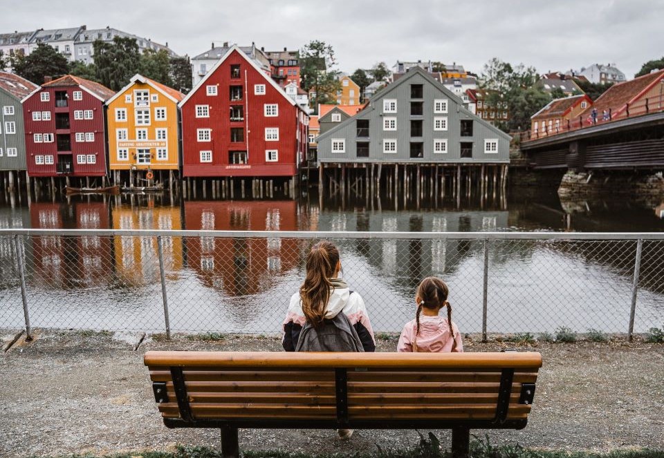 A woman and a child sitting on a bench in Norway